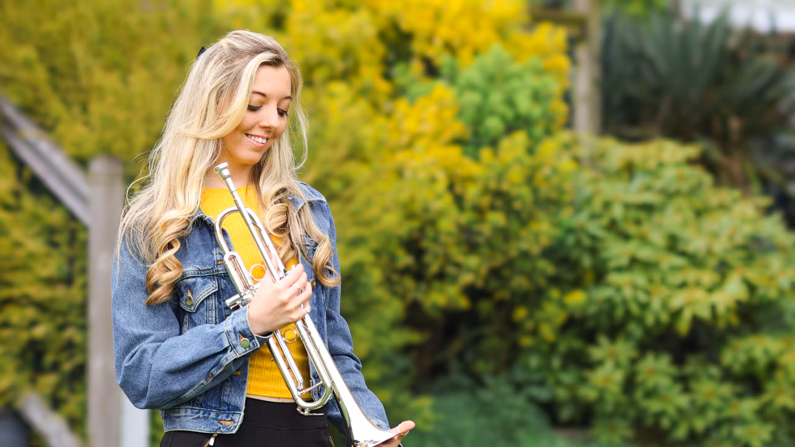 Jemma Andrews holding a silver trumpet outdoors — Teaching hero image.