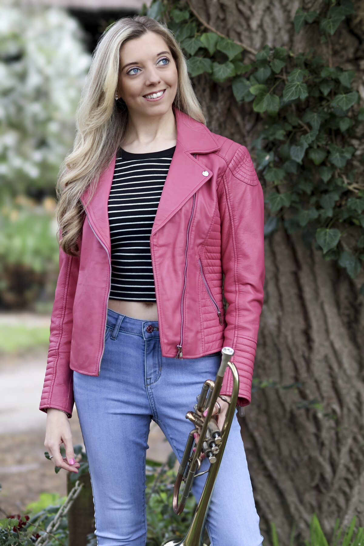 Jem Andrews portrait with trumpet in a pink jacket
