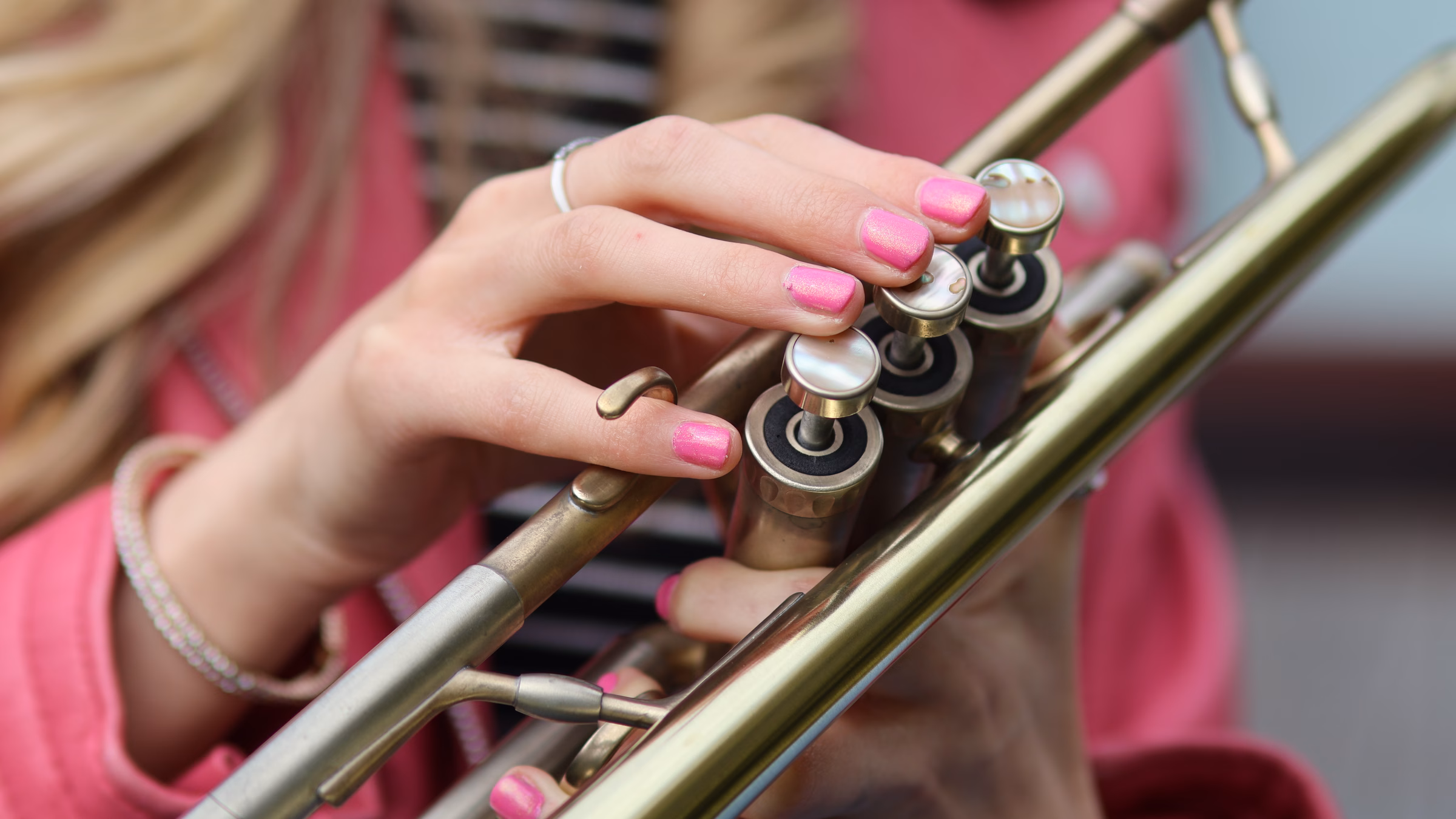 Jemma Andrews holding a coloured valve trumpet — Contact hero image.